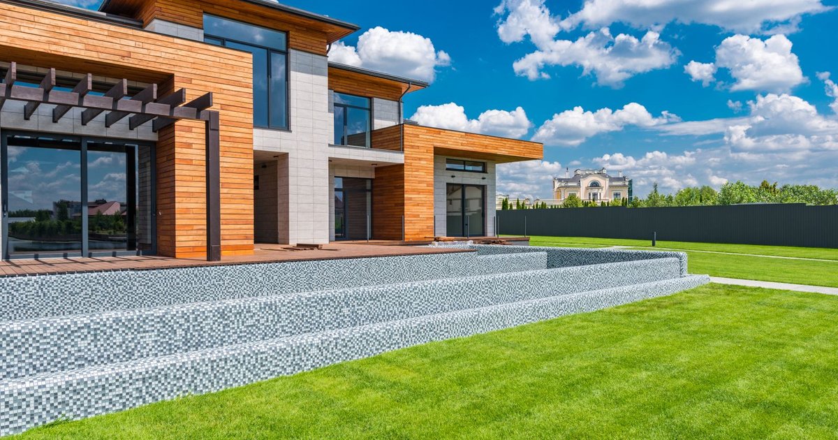Casa moderna con jardin pintada en verano bajo cielo despejado - Colorines